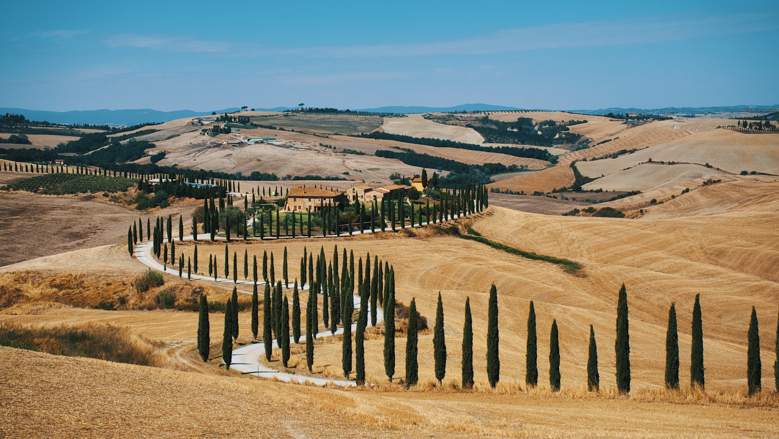 Paesaggio della Val d'Orcia con cipressi e colline dorate – Toscana